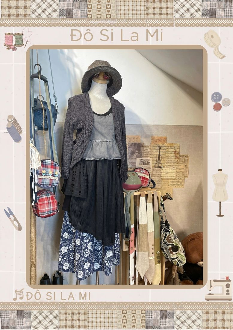 Áo xám phối cardigan đen, chân váy hoa nhí xanh navy, mũ bucket